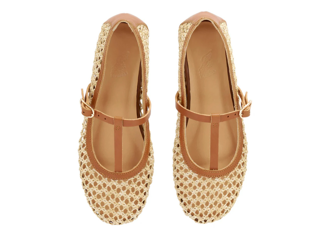 Pair of raffia shoes with a leather strap on a white background