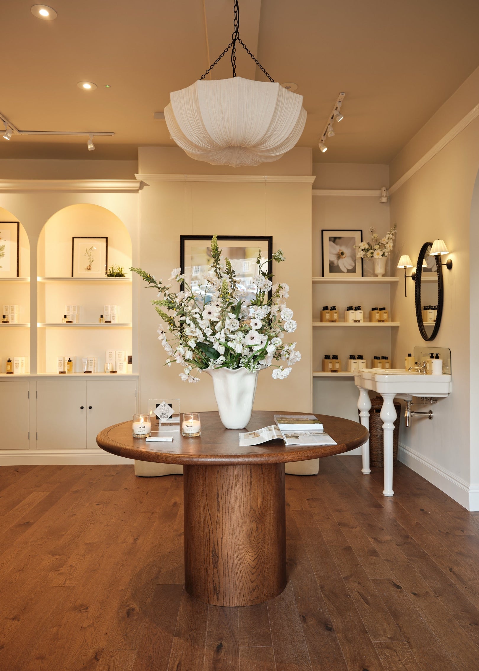Modern interior with a wooden table, white flowers, and decorative items.